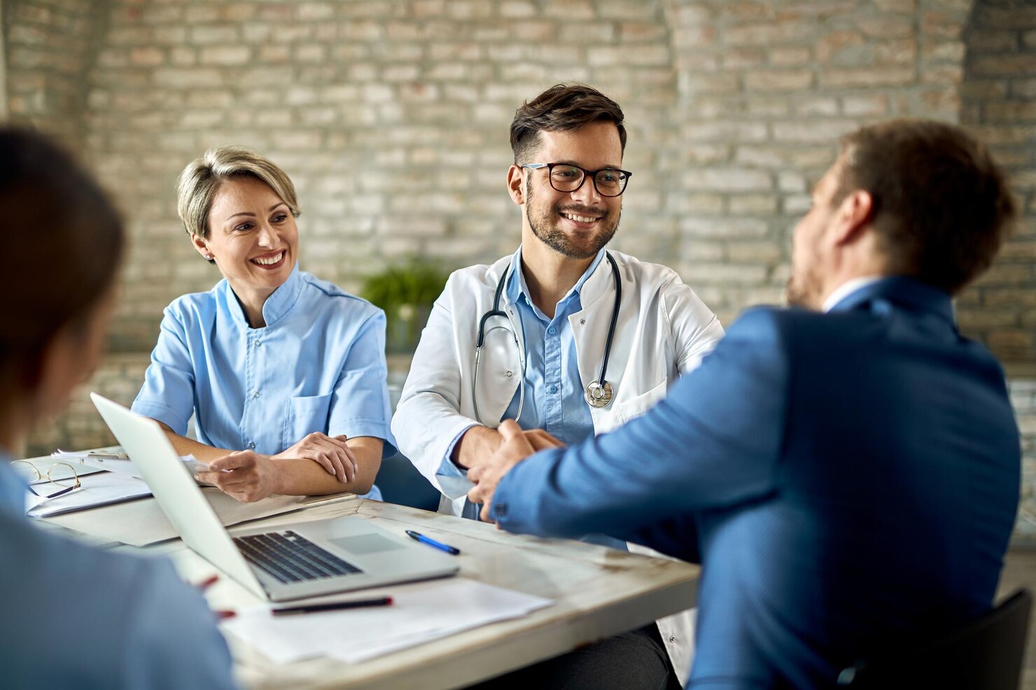 group-healthcare-workers-greeting-financial-advisor-meeting-office-focus-is-young-doctor_637285-6709